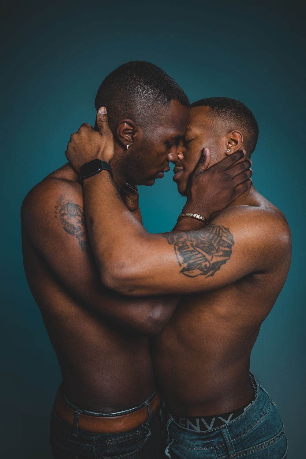 An artistic portrait against a teal background showcasing intimate connection and emotion.