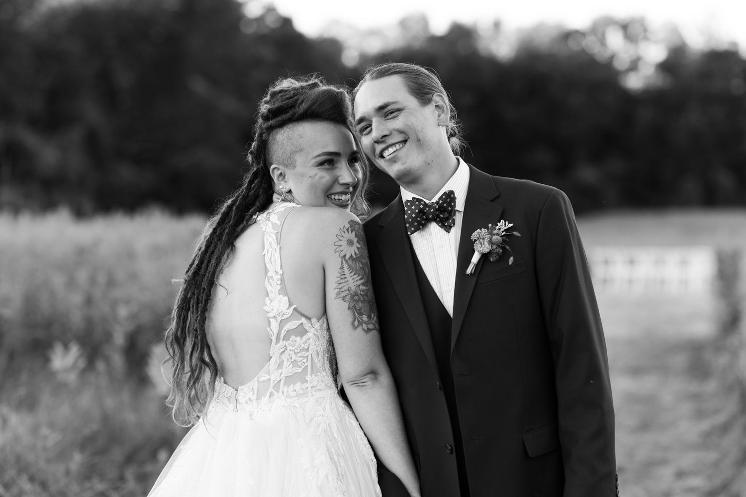 A tender black and white portrait of a couple in wedding attire sharing an intimate moment.