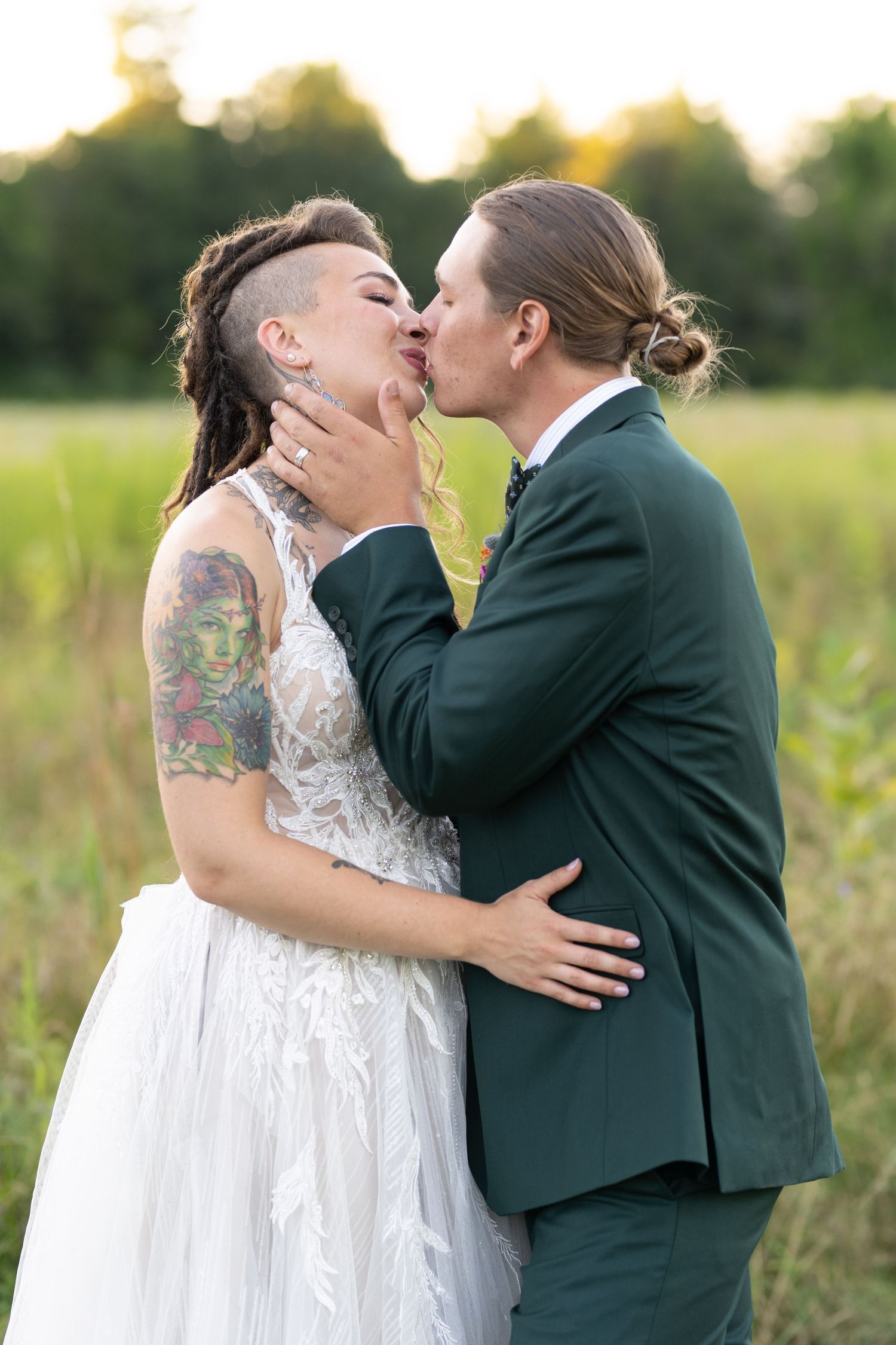 Intimate wedding portrait of couple embracing in a golden sunset field.