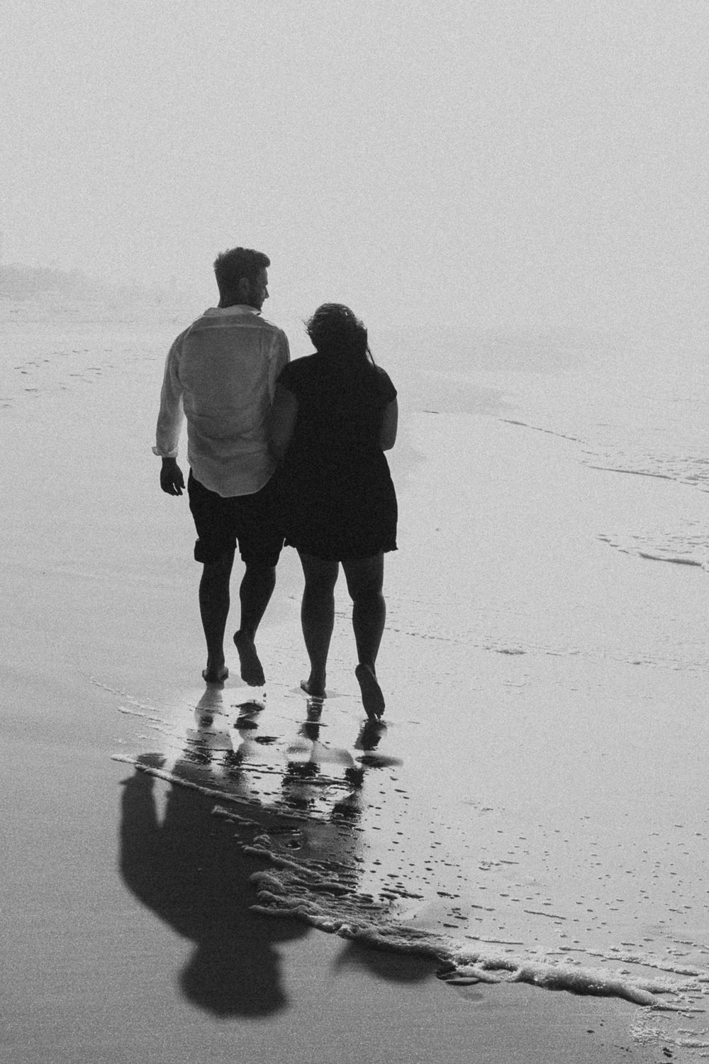 couple holding hands walking into the sunrise on okaloasa island during their sunrise session
