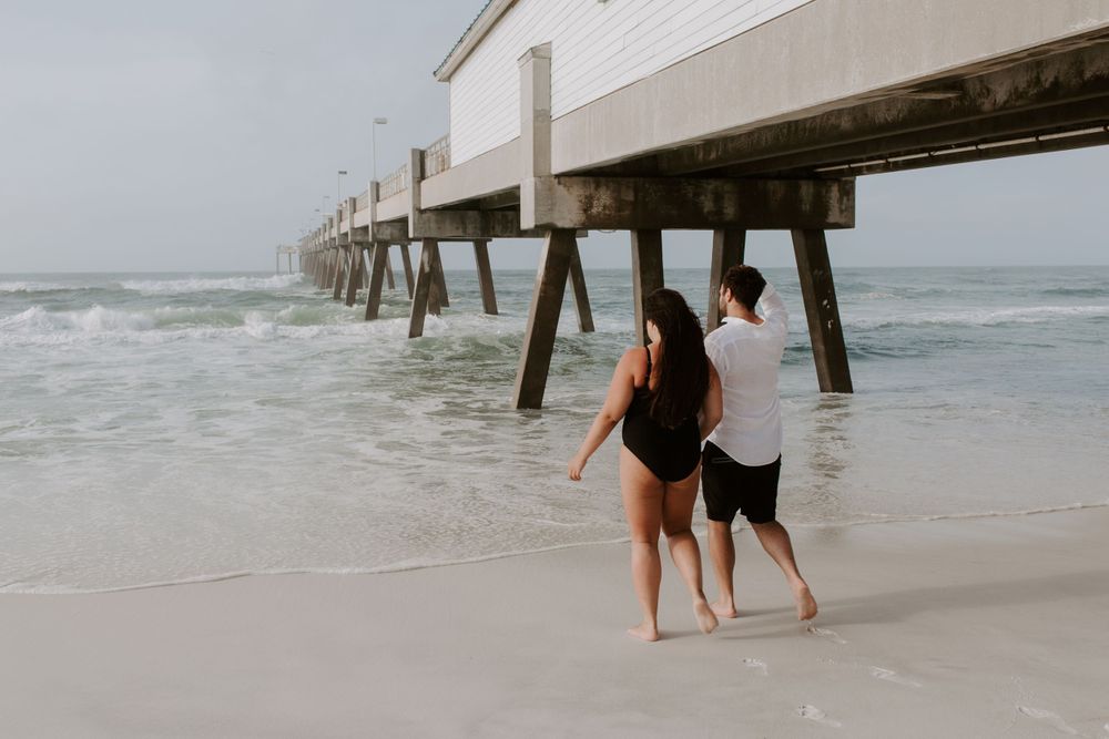 couple holding hands walking into the water from the beach during their Fort Walton Beach photo sunrise session