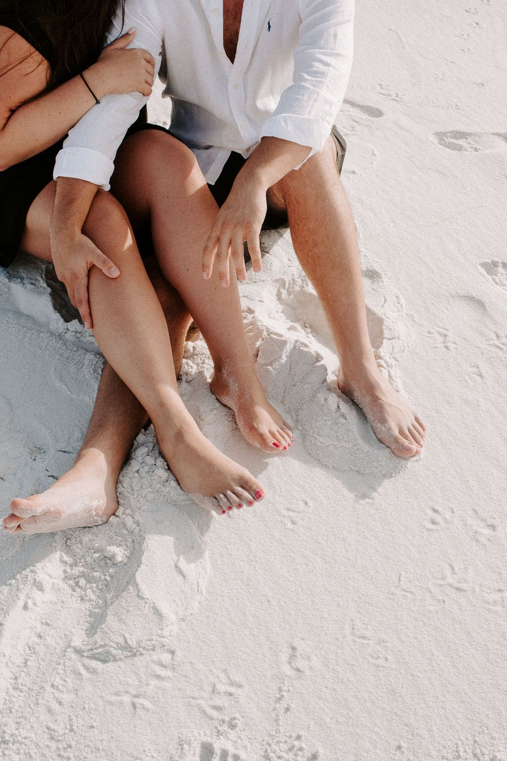 couples legs intertwined on the beach