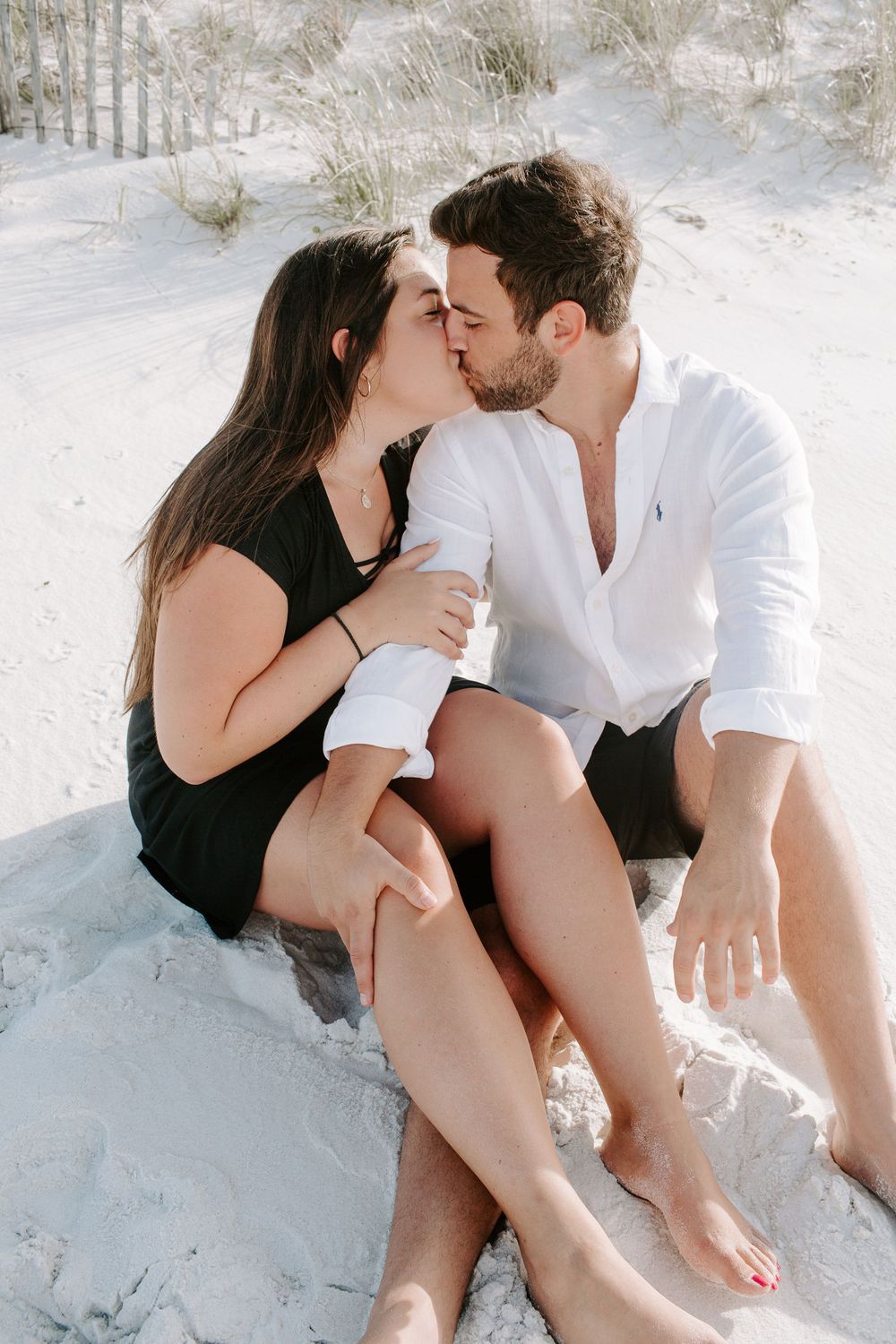 couple sitting on a beach kissing