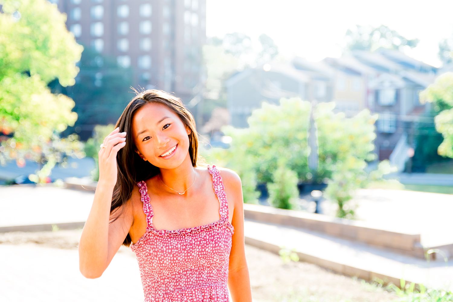 high school senior girl in red dress running hand through hair