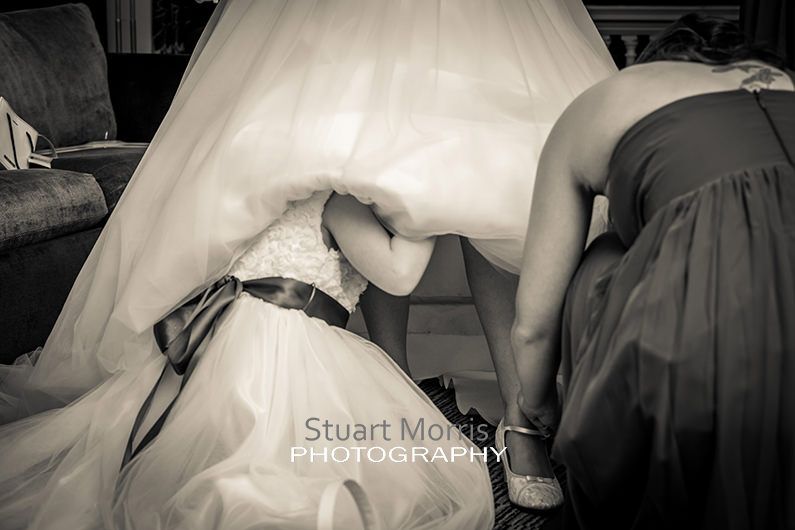 flower girl climbs under the brides wedding dress