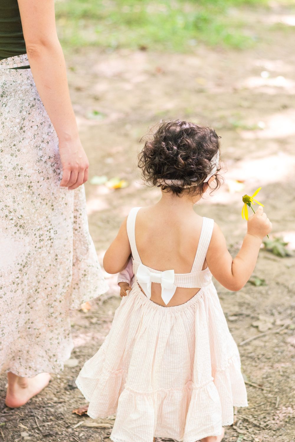 Toddler holding flower in woods in Pittsburgh, Pennsylvania