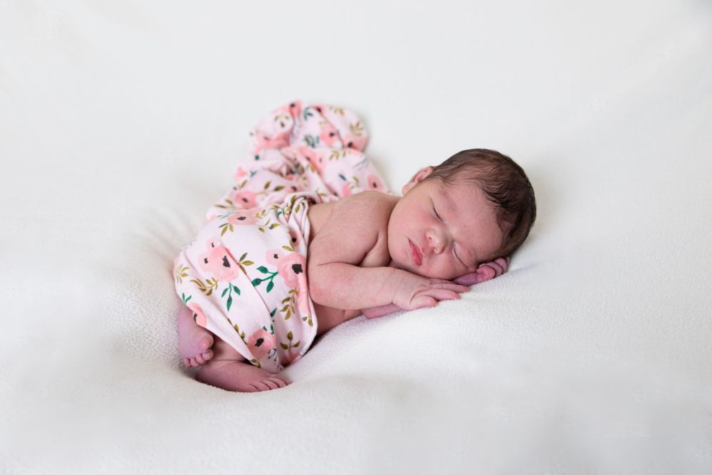 Newborn photography of sleeping baby in floral swaddle