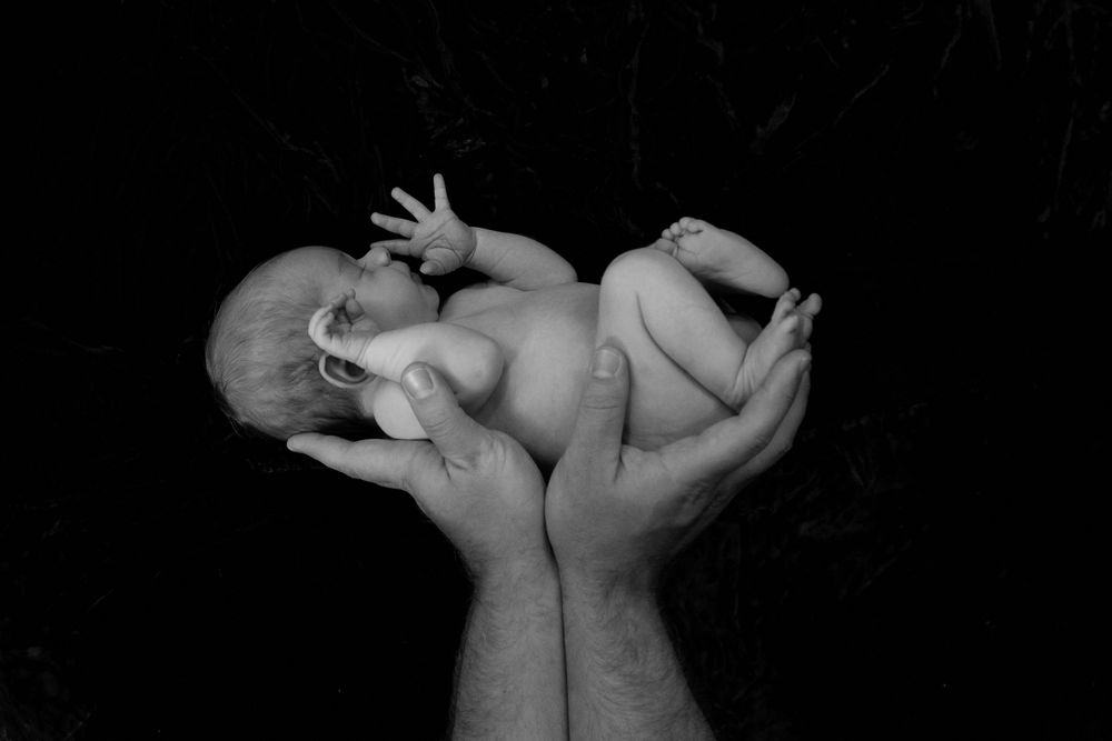 black and white Newborn photography of sleeping baby in hands