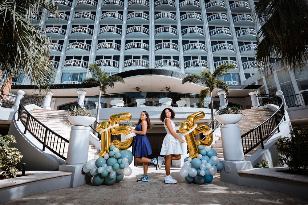 An elegant entrance to a hotel decorated with blue balloons and gold accents.