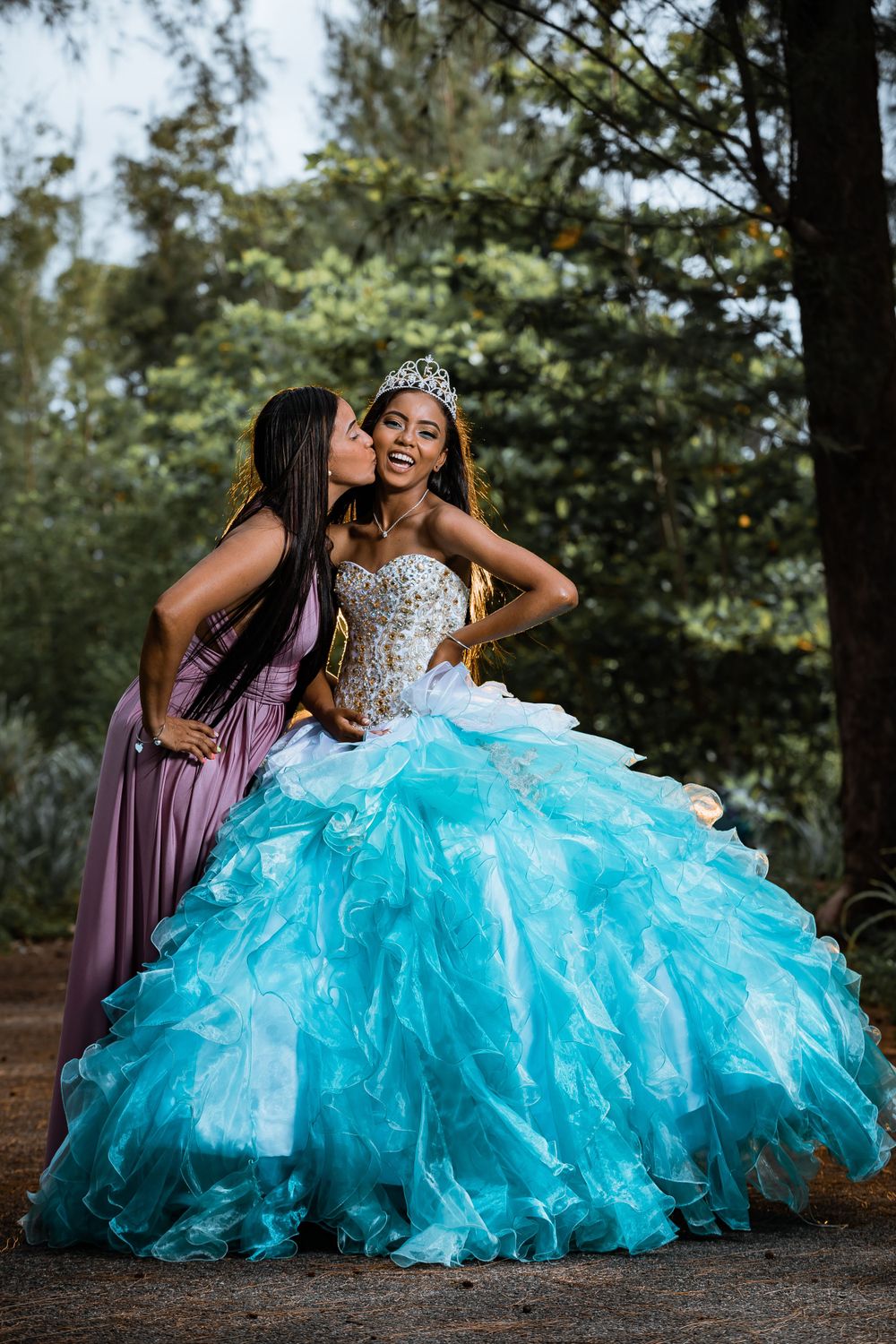 A heartwarming moment captured during a quinceañera photo session in a forest setting.