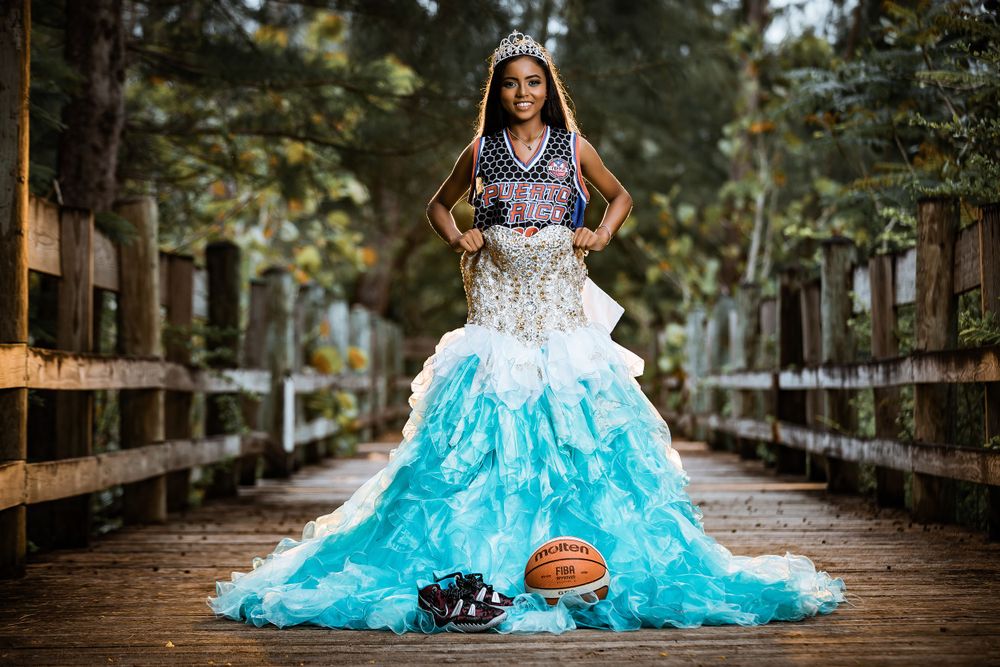 Dramatic portrait on wooden bridge wearing turquoise ball gown with basketball and sneakers as props.