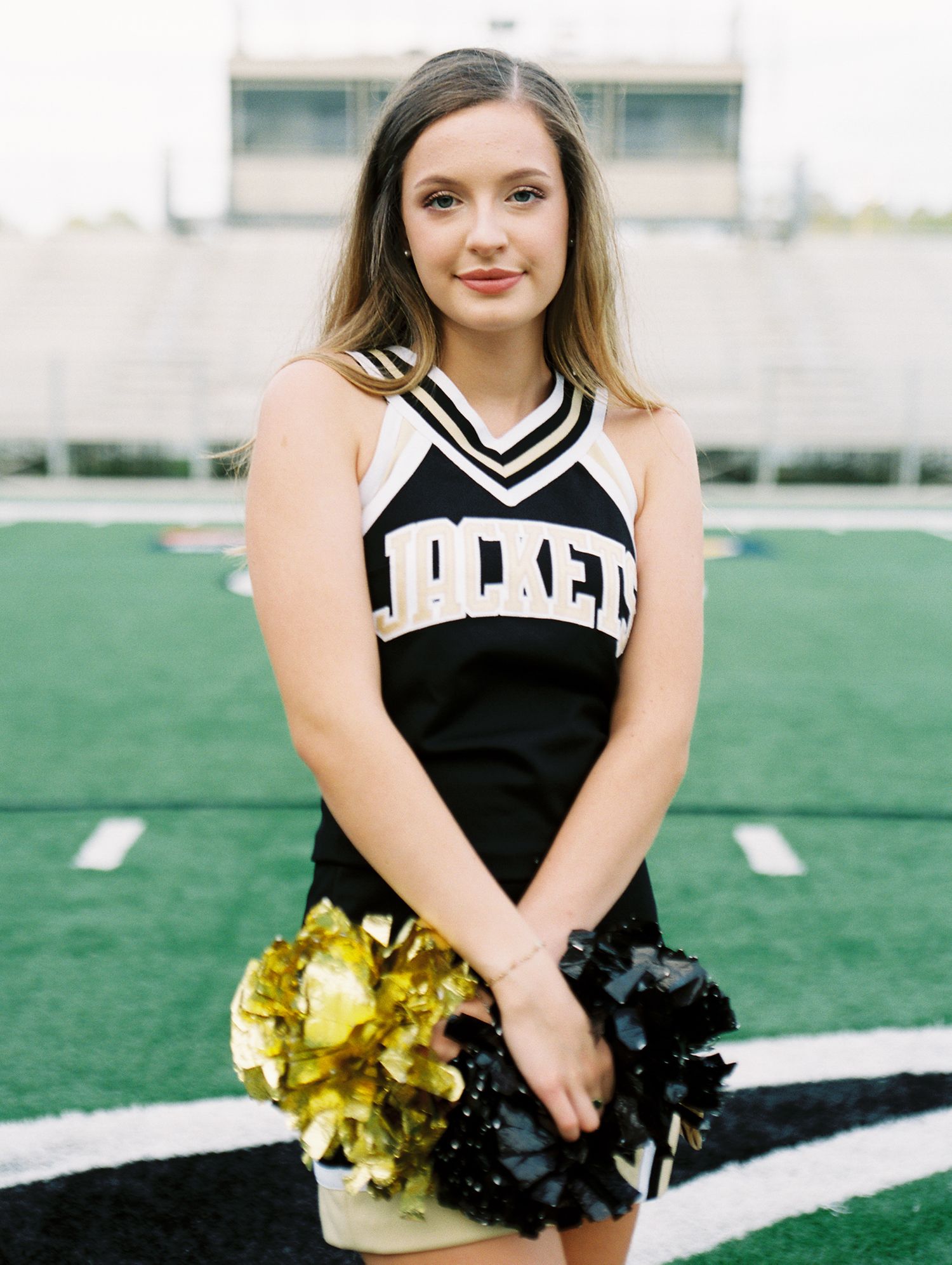 Louisiana senior portrait photography of Oak Forest Academy cheerleader in the football stadium