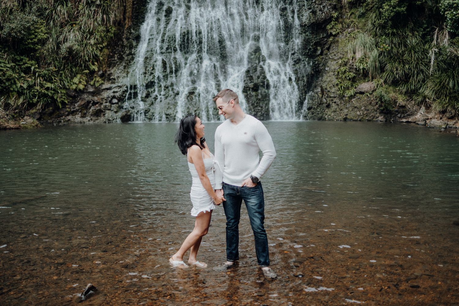 A couple in frot of Karekare falls for their post-wedding photoshoot with Apertured Media-Auckland Wedding Photographer.