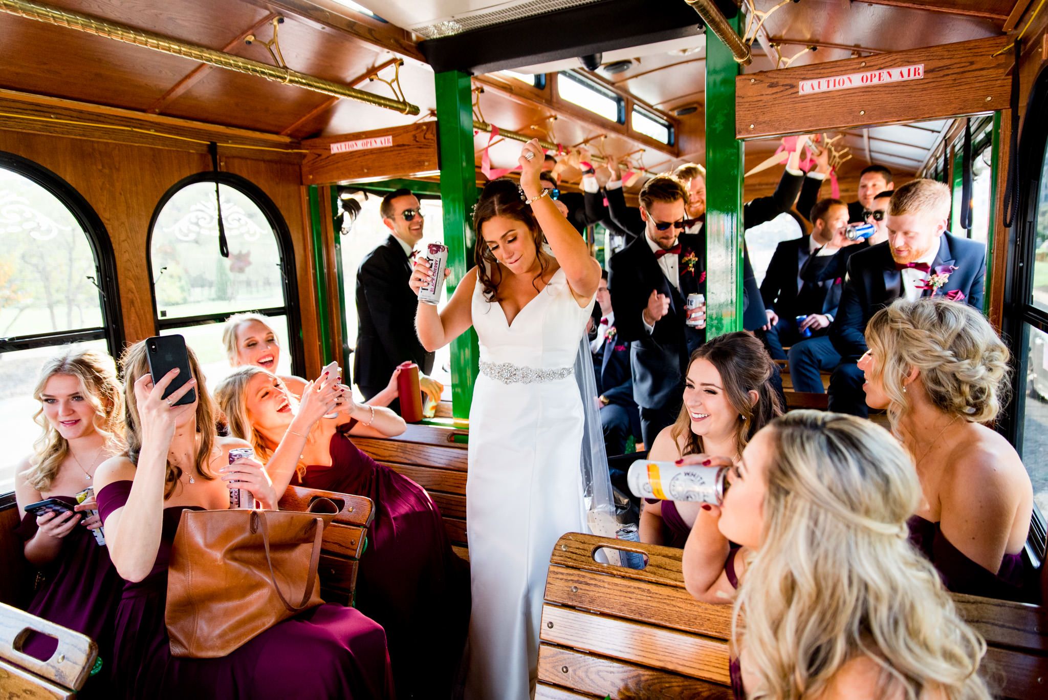 laughing wedding party dances on green and brown trolley after fall chicago wedding