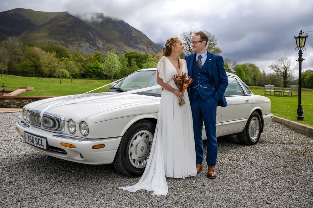 Bride and groom with wedding car at New House Farm in Cumbria