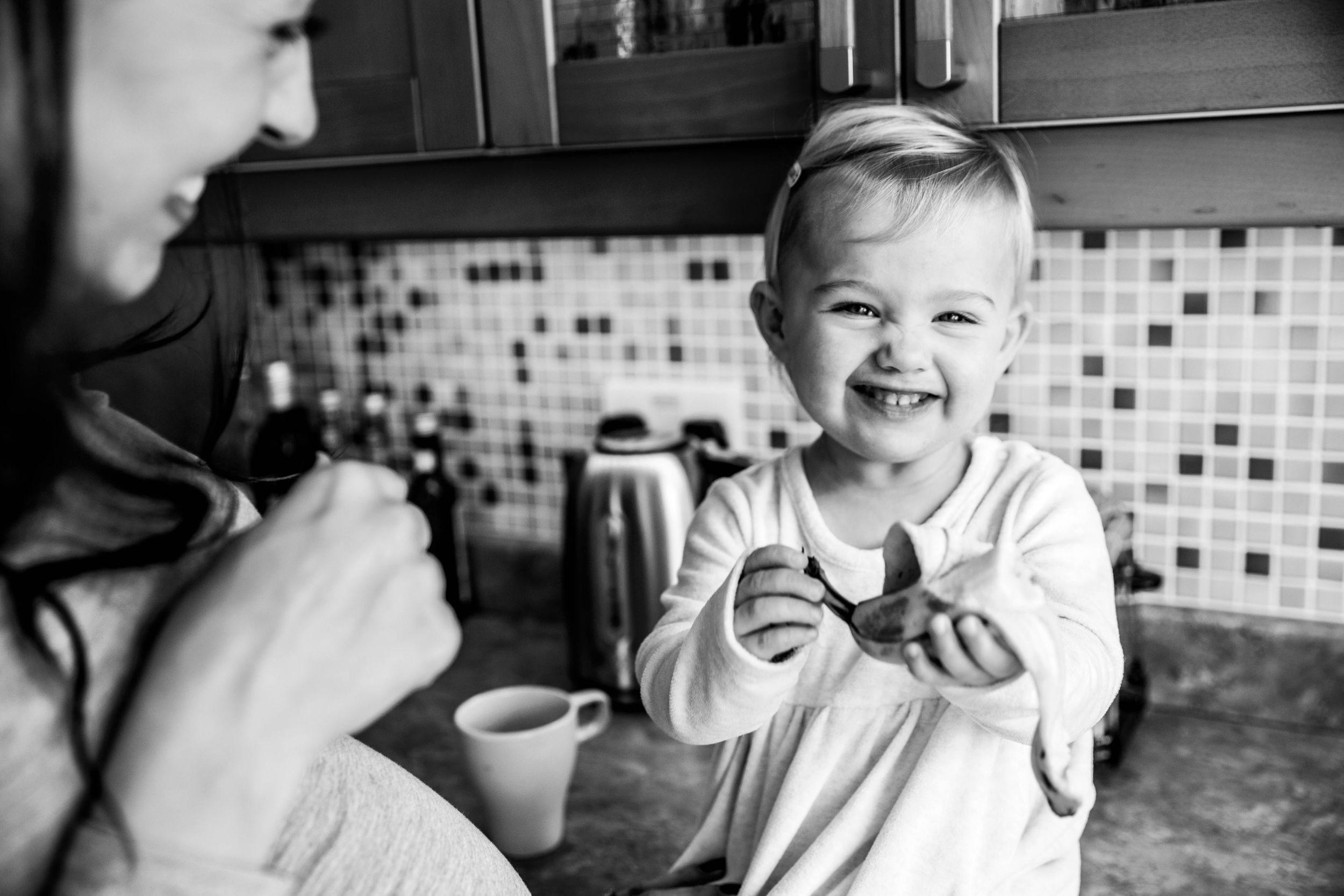 little girl eating banana smiling