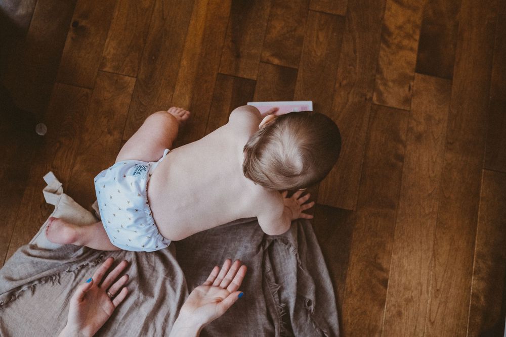 Maman qui guide son bébé qui quitte à quatre pattes