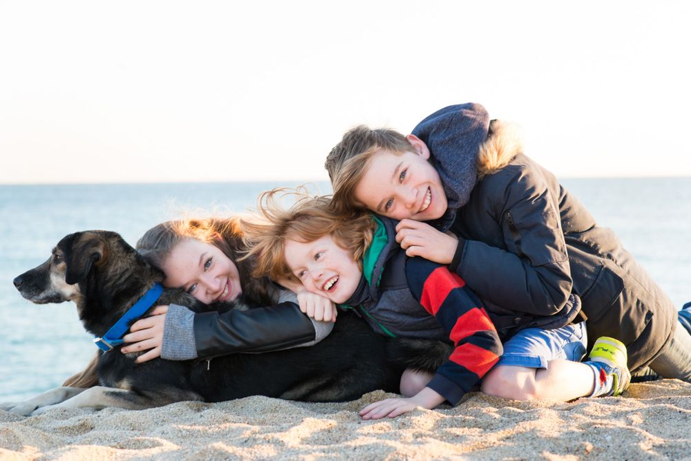 3 children and their dog during a photo session in Ocata Beach just outside of Barcelona.