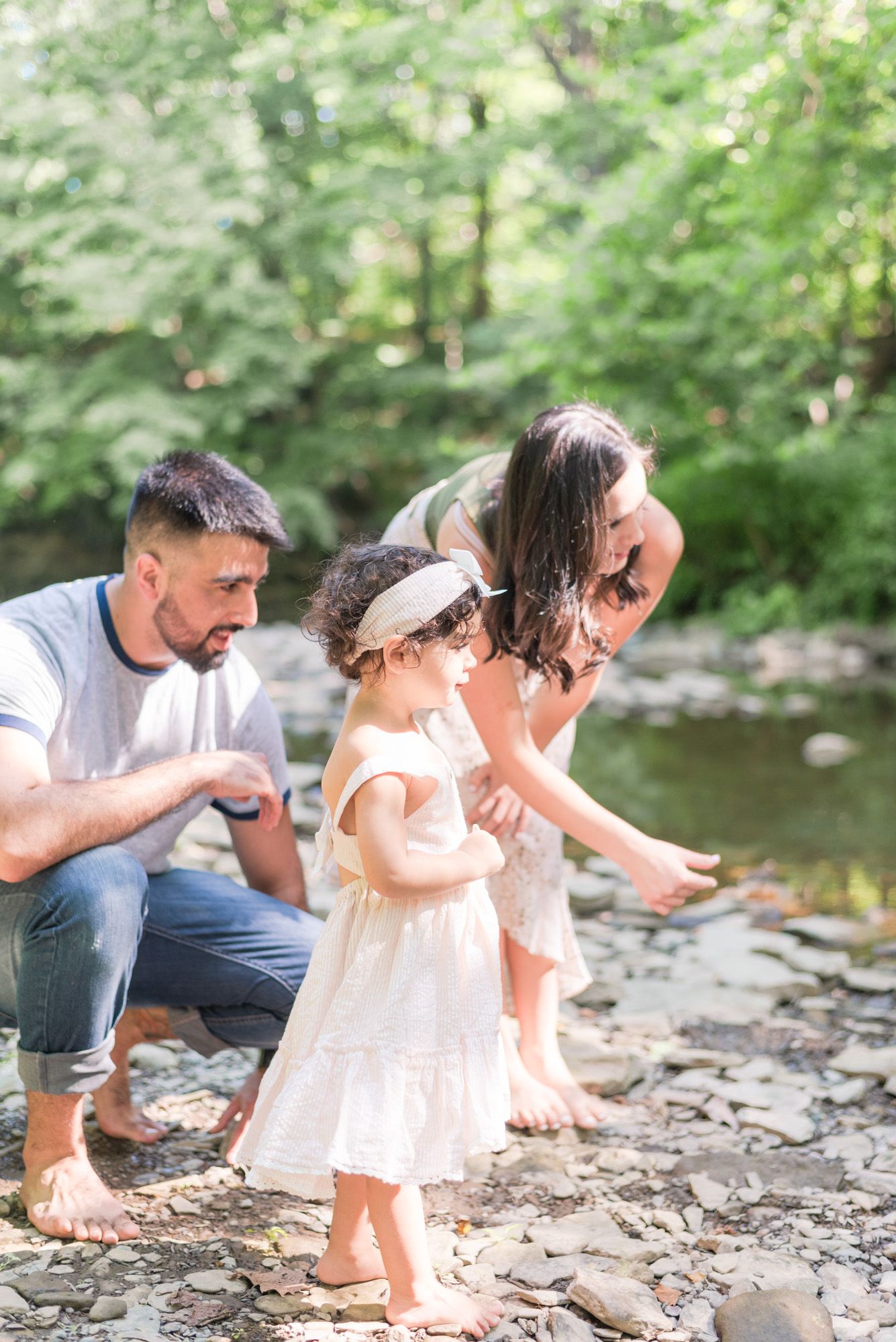 Family with toddler skipping stones in a creek in Pittsburgh, Pennsylvania