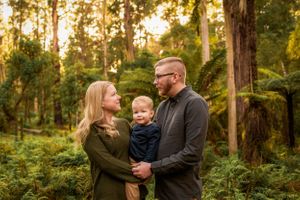 Parents and toddler standing amongst treeferns in Melbourne