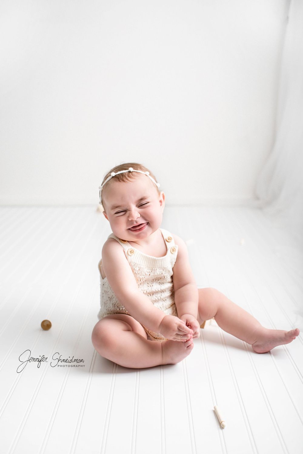 Baby Milena smiles cheekily at the camera during her minimalist birthday session.