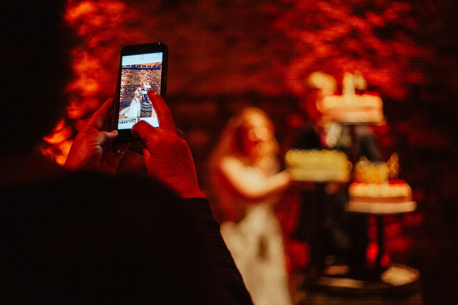 Kinkell Byre Wedding Photography, Guest takes snapshot of bride and groom cutting the cake
