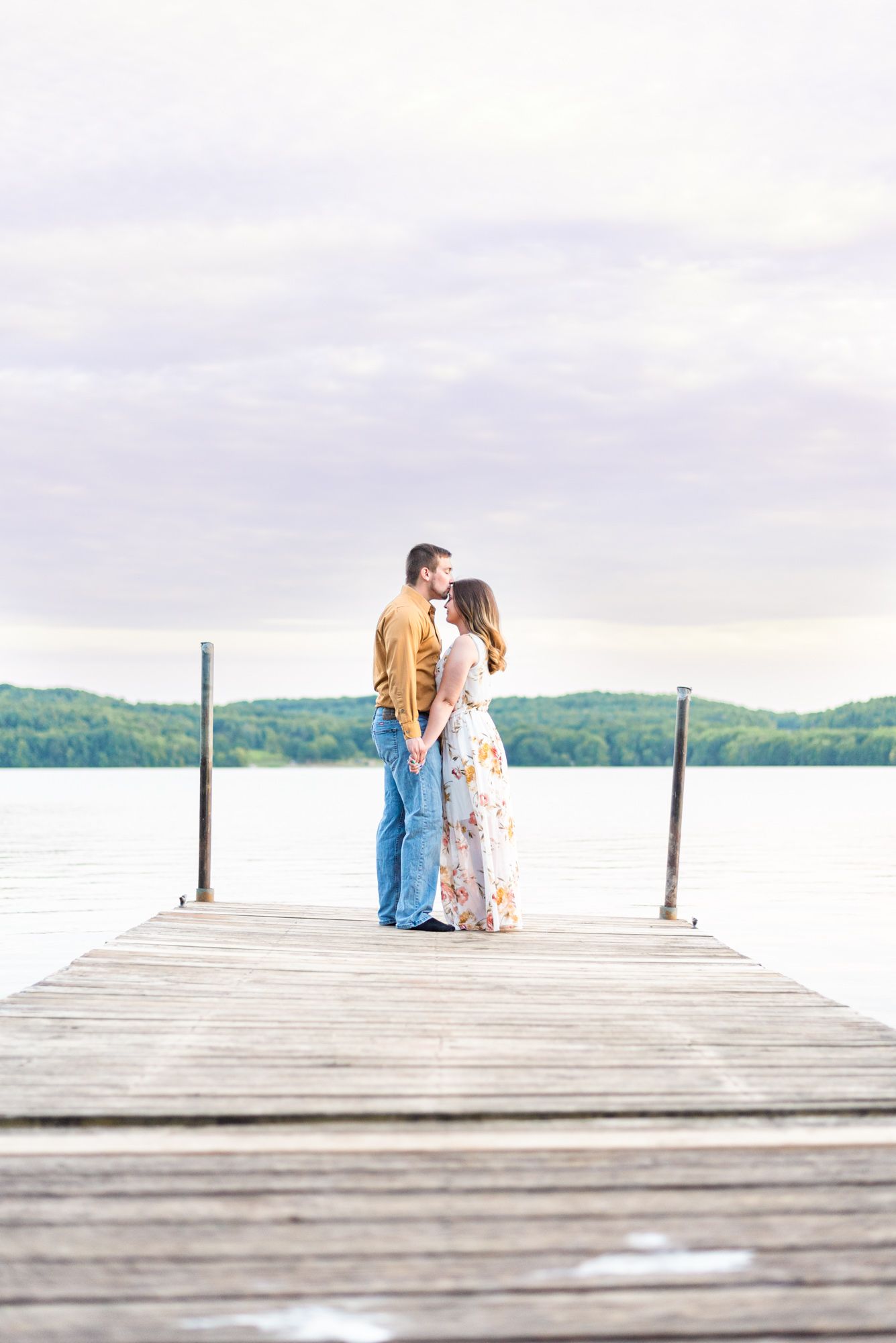 Couple kissing on dock of Lake Arthur at Moraine State Park in Pennsylvania