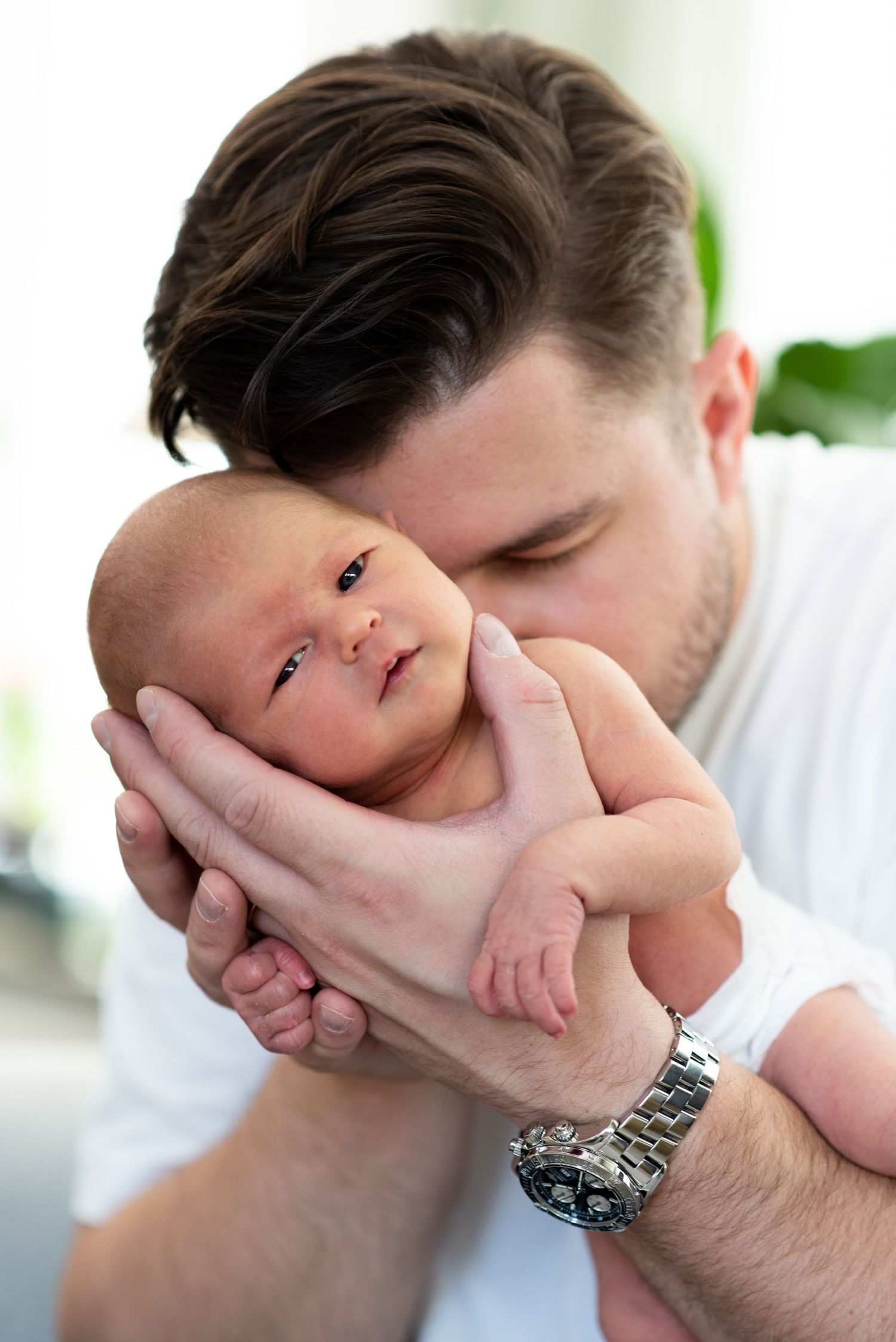 Porträttbild på far och nyfödd dotter