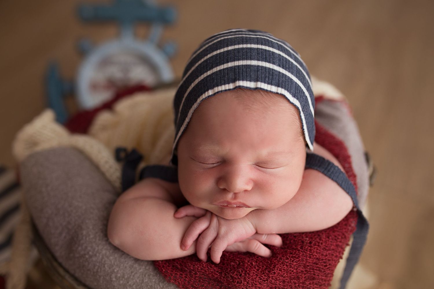 newborn photos chin on hands in pose in bucket
