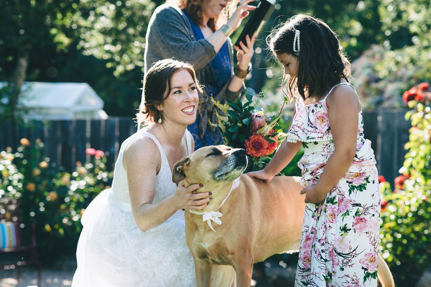 Bride introducing little girl to her dog of honor at their small backyard wedding in Santa Cruz.