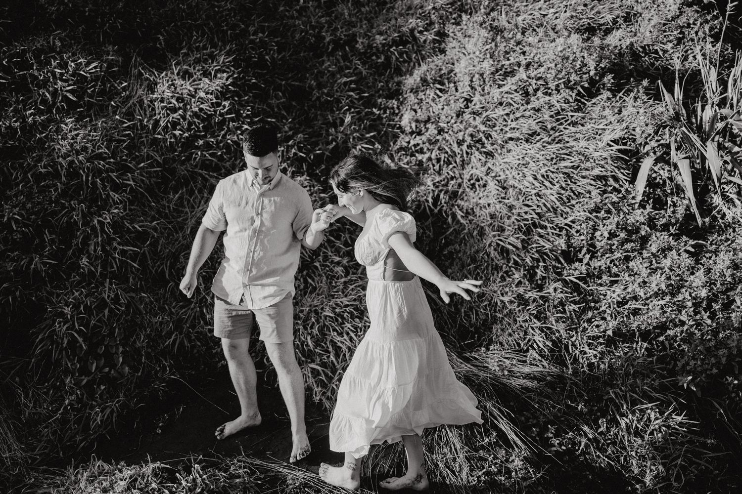 Couple hiking to Karioitahi Beach in their engagement shoot with Apertured Media-Auckland Wedding Photographer