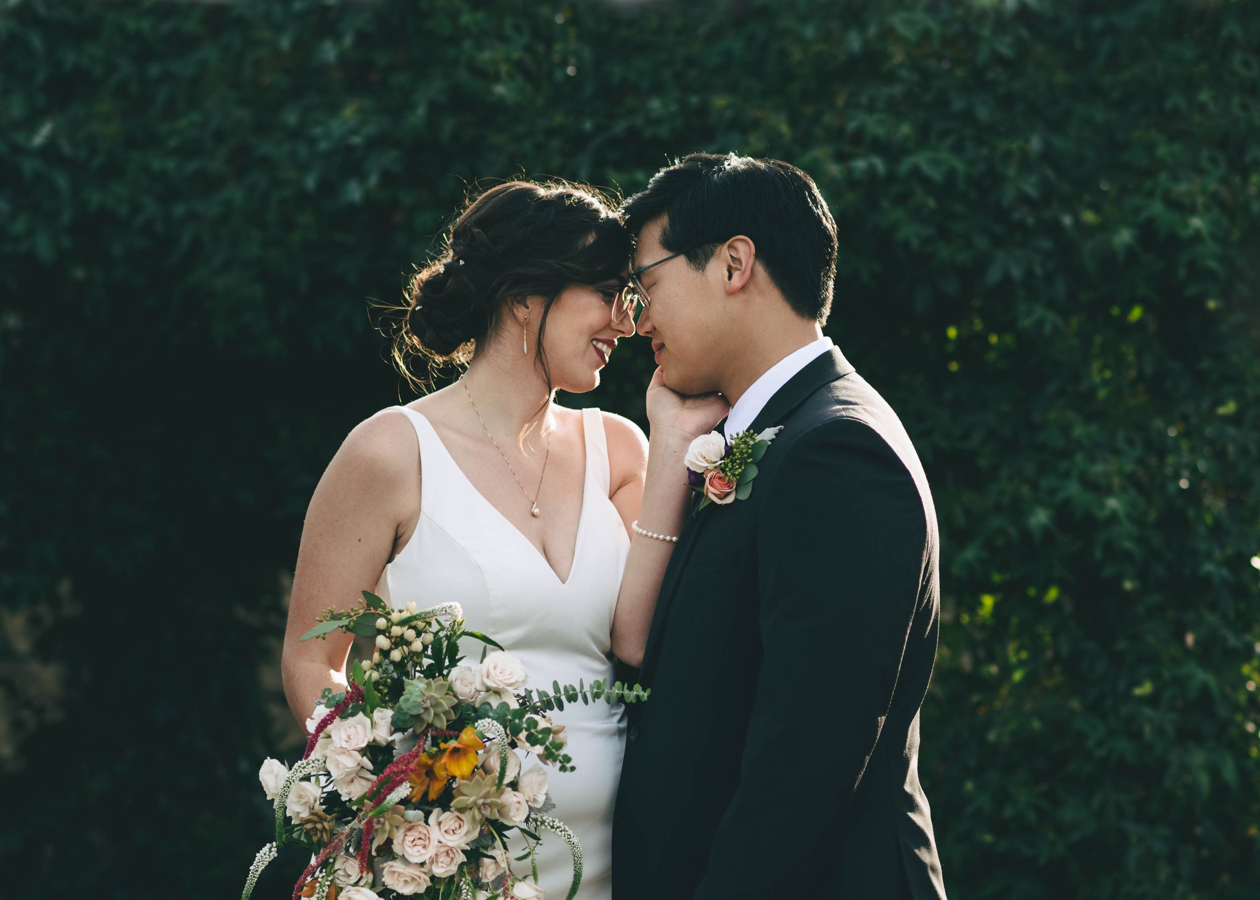Bride and groom, heads touching, in the garden at the barns at cooper molera in Monterey