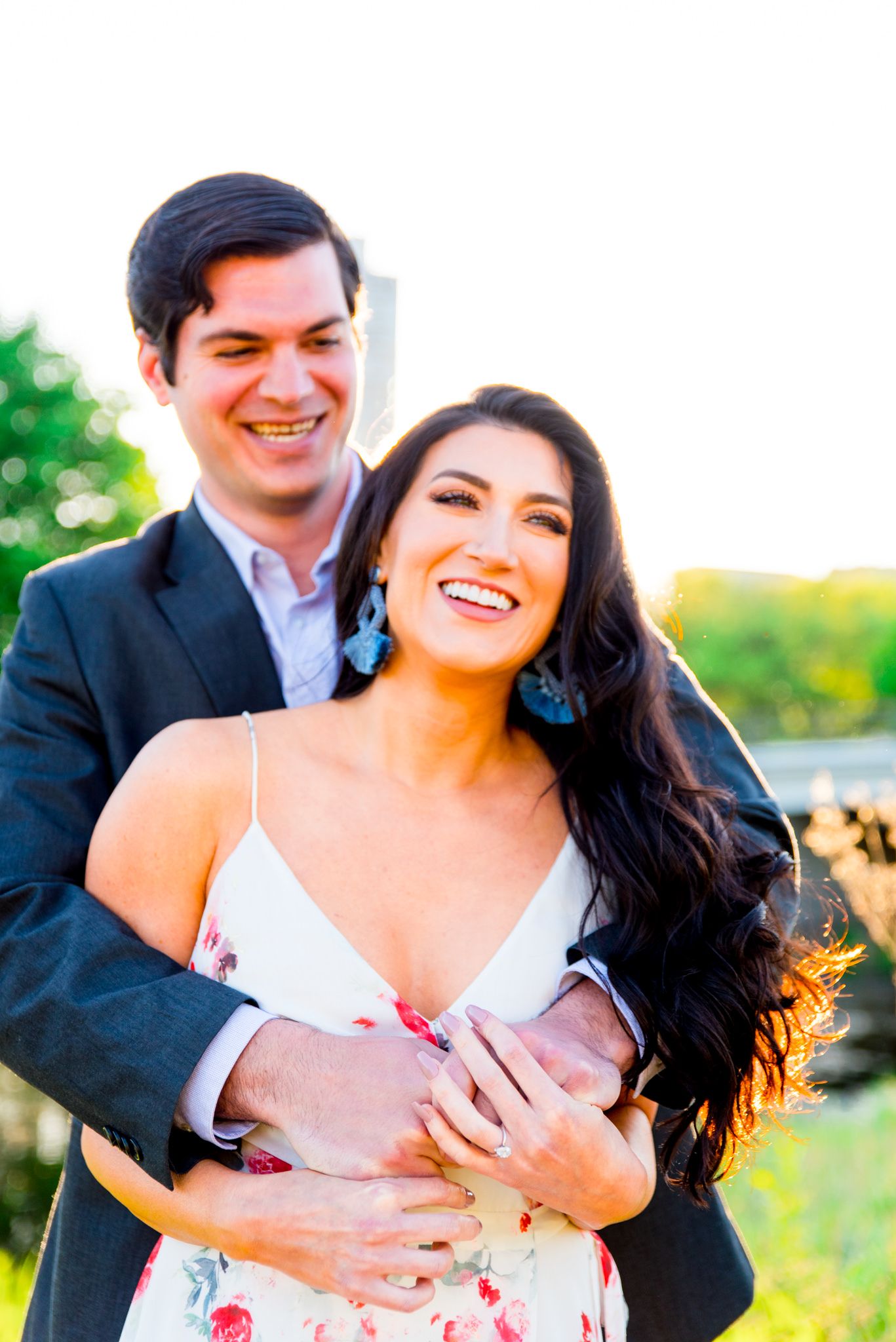 man hugging woman from behind making her laugh for Lincoln Park engagement pictures