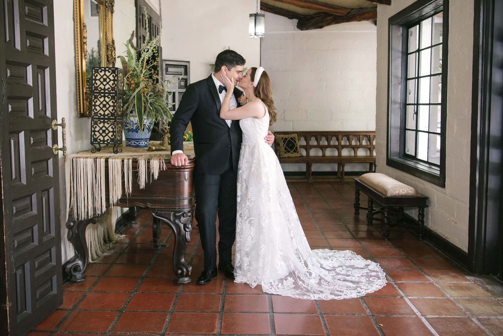 bride kissing the groom next to the piano. McAllen wedding photographer. quinta mazatlan