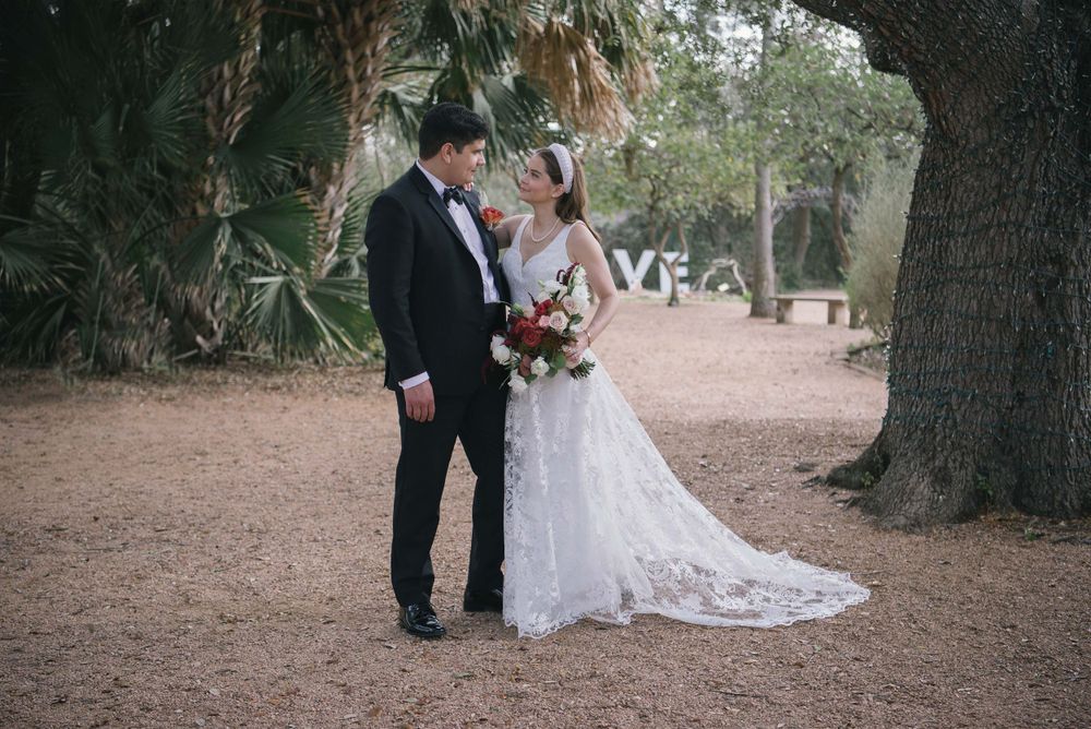 bride and groom looking at each other next to a tree. Mcallen wedding photographers