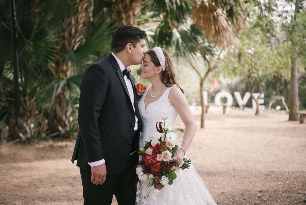 Groom kissing bride's forehead next to a tree McAllen TX wedding photography