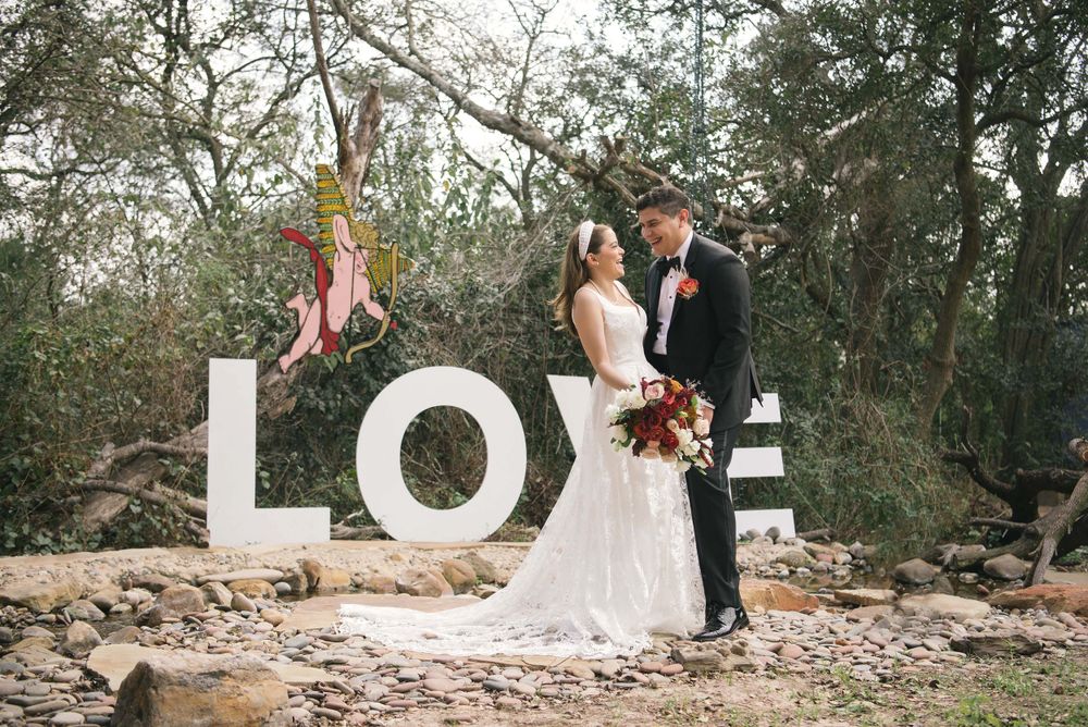 bride and groom standing in front of the love letters. Quinta mazatlan. photographer