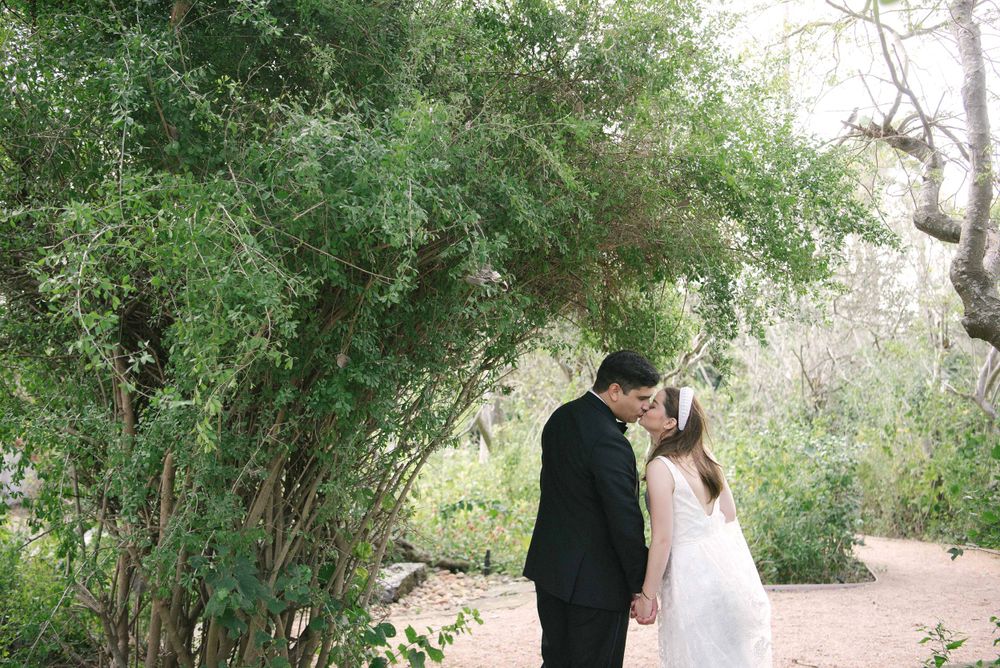 Bride and groom kissing next to a tree. Quinta mazatlan. McAllen TX