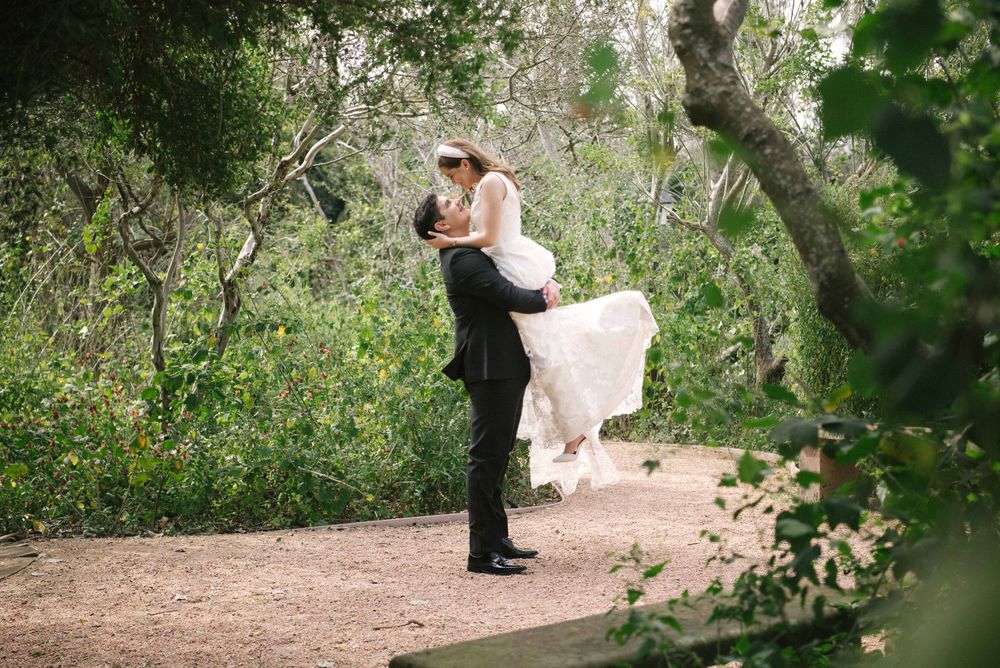 Groom lifting the bright under the tree. Mcallen wedding photography