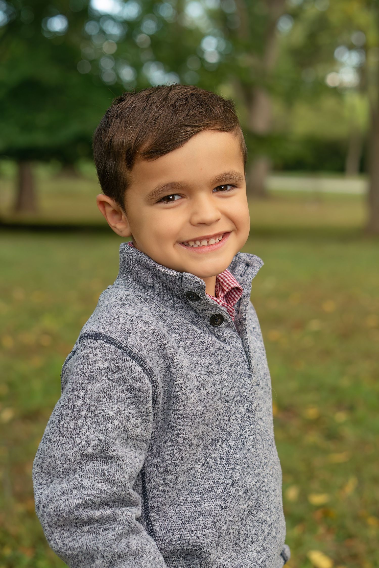 young boy smiles in nature scene