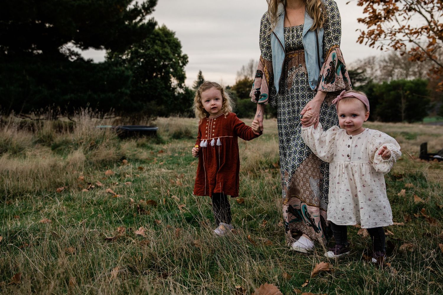 Mum holding kids hands walking
