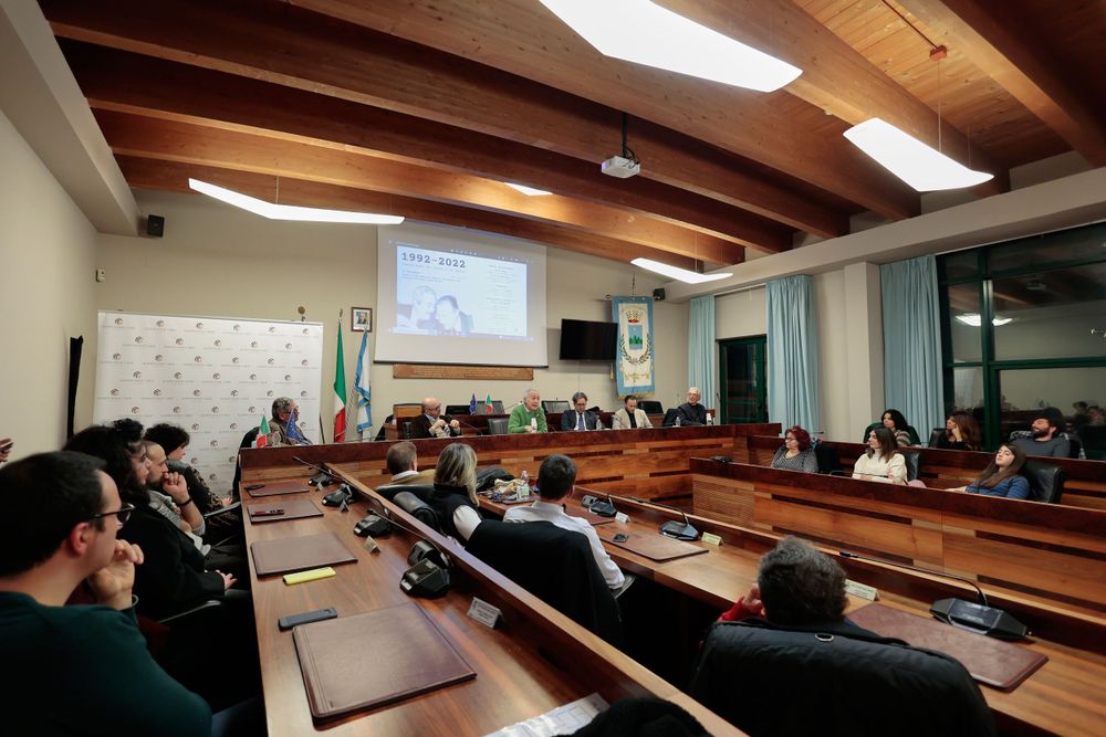 Wide view of conference room with wooden beams and presentation screen during meeting.