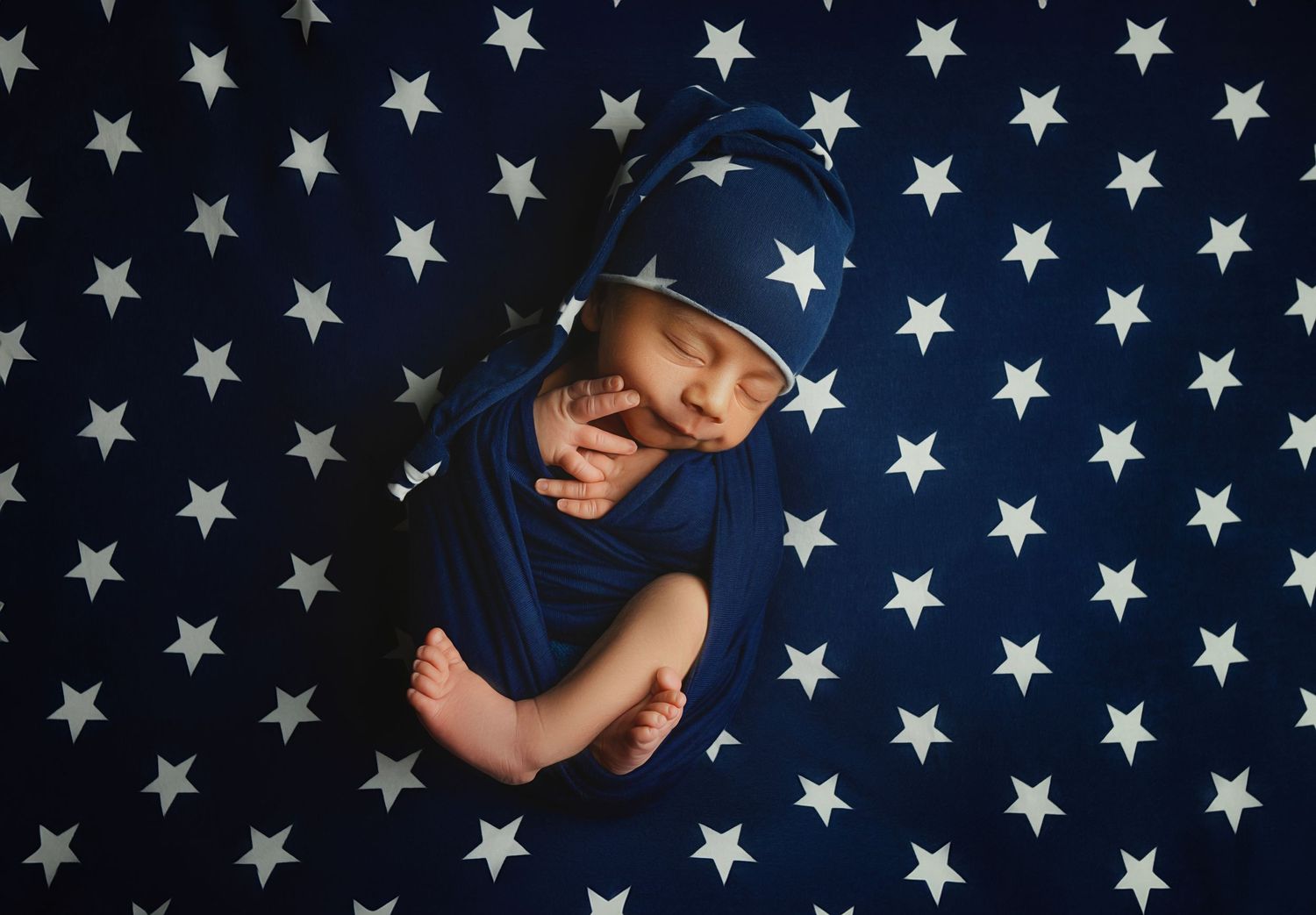 A charming portrait of a baby boy surrounded by blue star decorations, capturing his innocence and playful spirit in a c