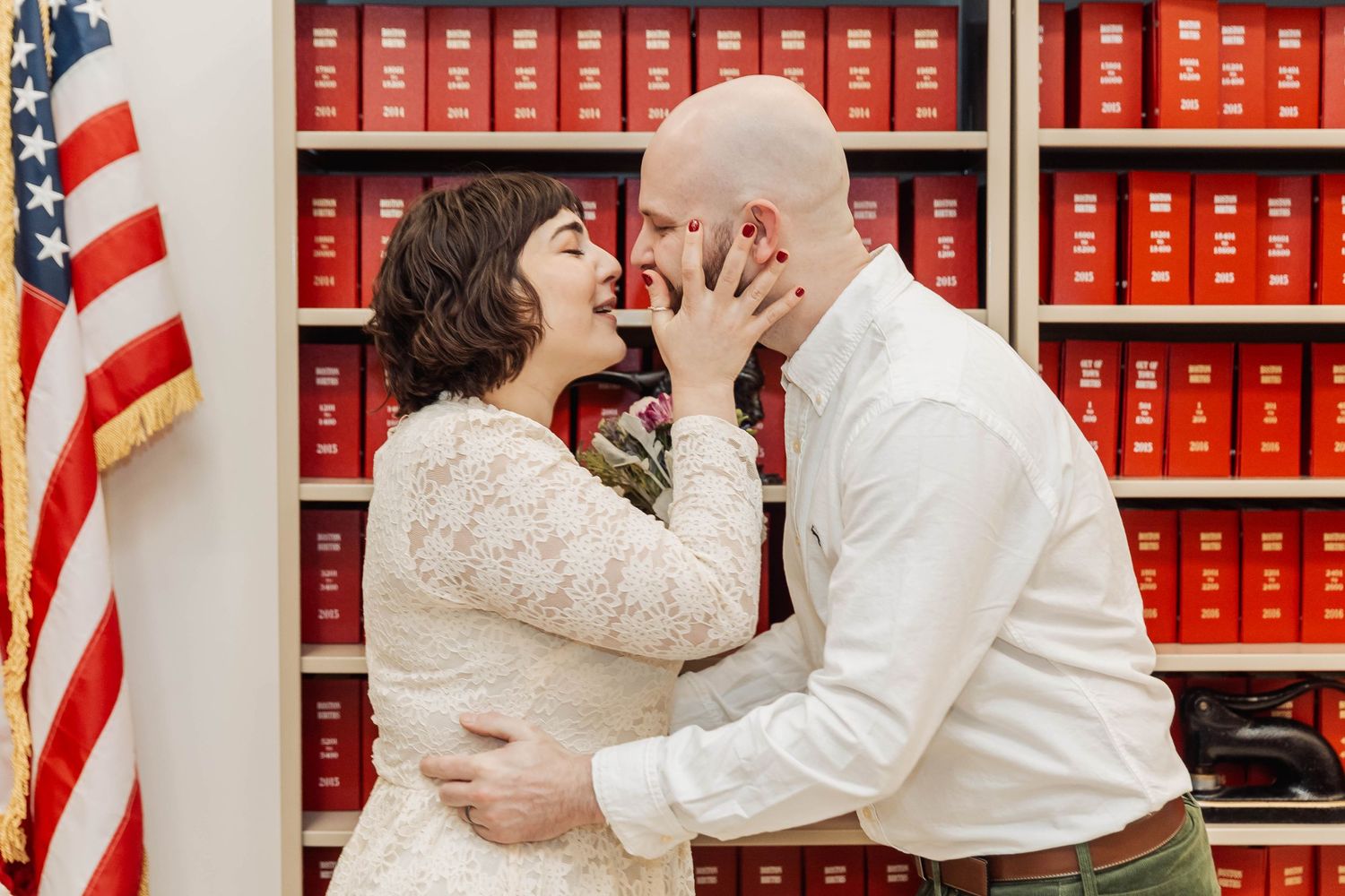A romantic moment between newlyweds in front of law library shelves.