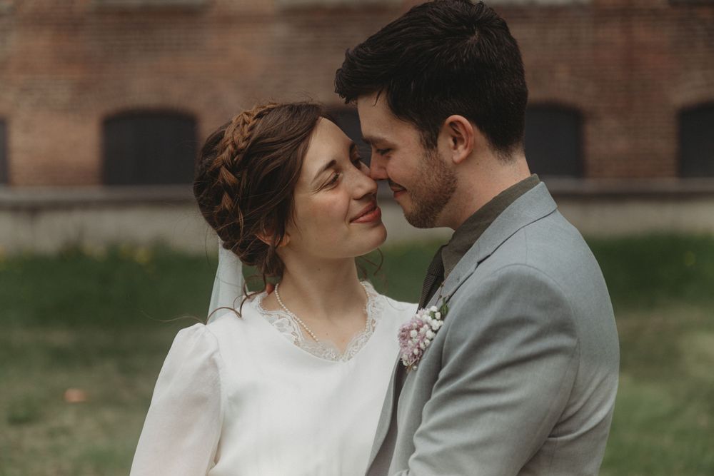 Intimate wedding portrait captured in front of brick building.