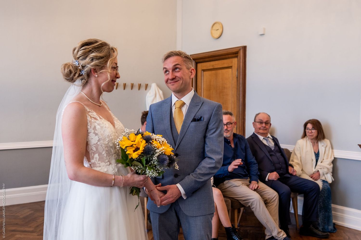Two people sharing a sweet moment at a wedding ceremony while guests watch from the seating area.