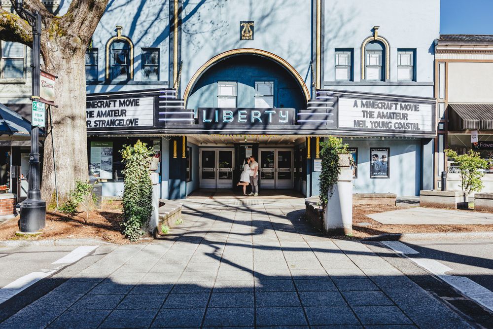 Historic art deco Drexel Theatre with blue facade and marquee on a small town main street sidewalk in Columbus Ohio.