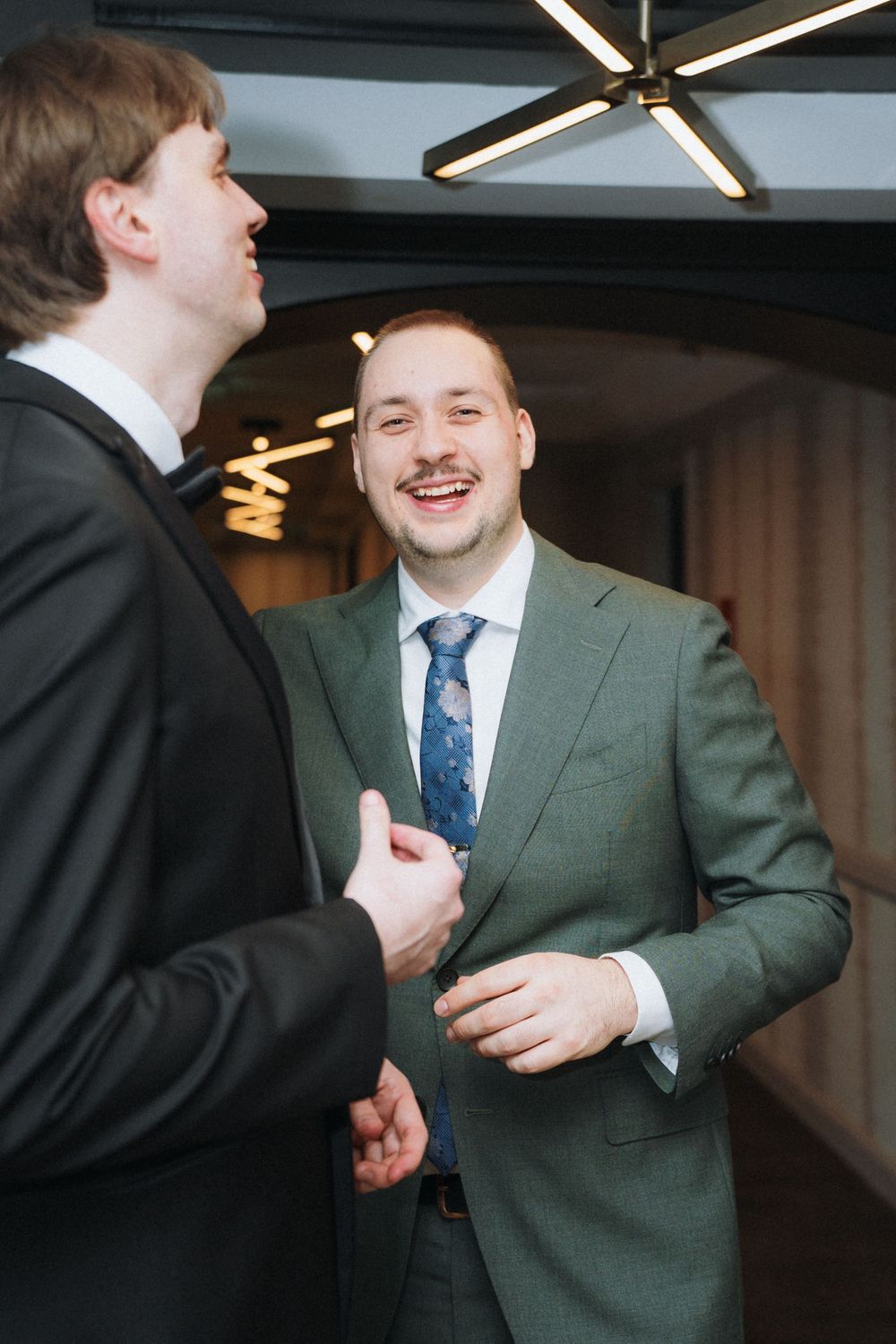 Two people in formal attire sharing a candid laughing moment.