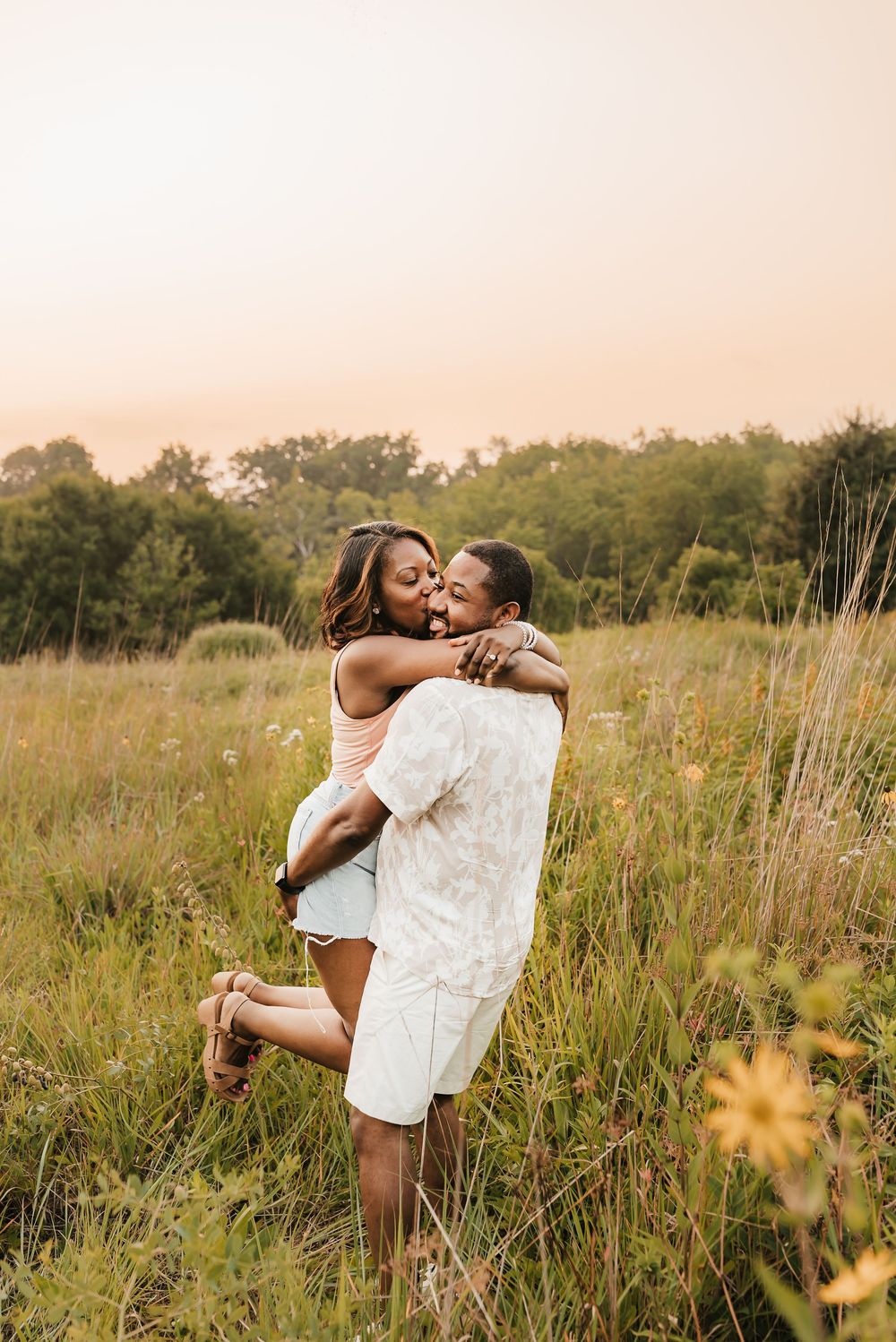 husband spins wife around romantically in a sunflower field at French park in cincinnati