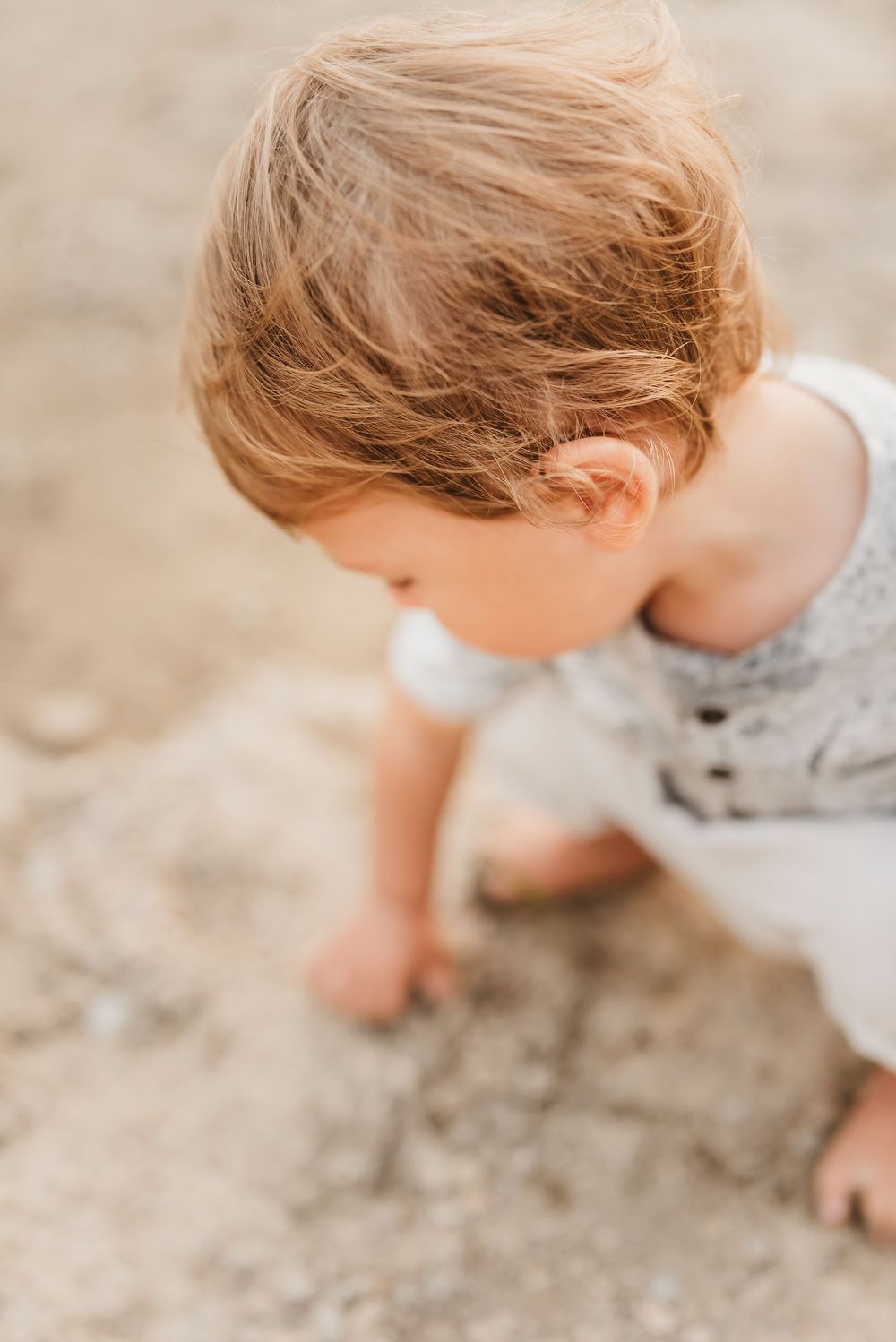 toddler boy plays with rocks near the little Miami river near cincinnati